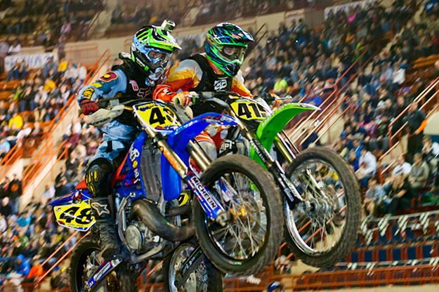 Two bikes and riders locked together in a jump. Photos Motorama 2013
