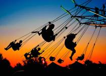 Kids on carnival swings at sunset